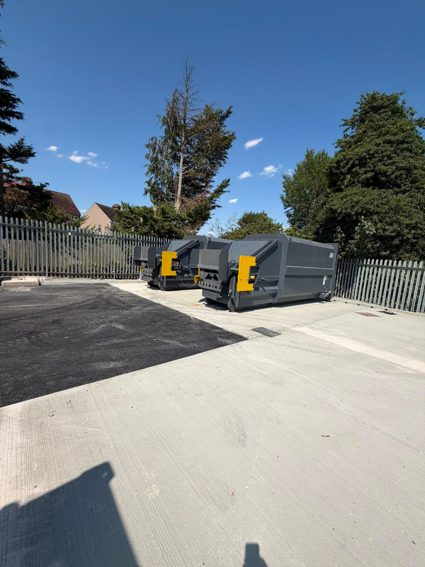 Two static compactors positioned on a new concrete slab beside the recovery compound